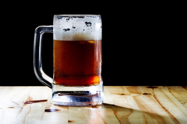 selective focus dark beer and foam with Beer mug and soft flare filter
