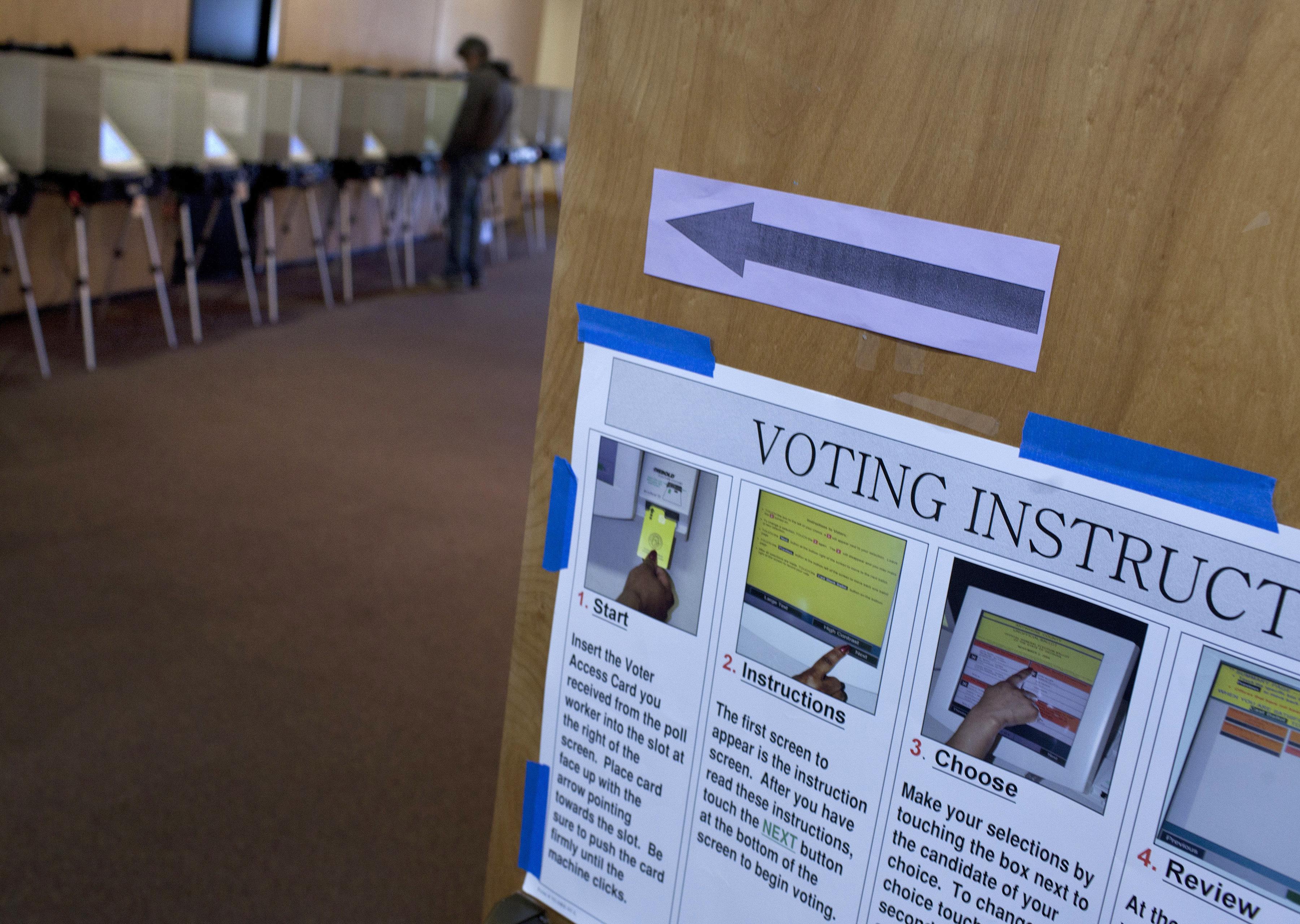 A voter casts his ballot at a voting mac